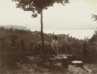 [Femme tenant un battoir à coté d'un bassin dans lequelle trempe du linge] / [non identifié]. [1910]