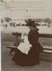 [Femme assise sur un banc tenant dans les bras un bébé en robe de baptême] / [non identifié]. [s.n.], [Entre 1903 et 1905]. [1903]-[1905]
