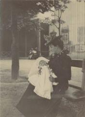 [Femme assise sur un banc tenant dans les bras un bébé en robe de baptême] / [non identifié]. [s.n.], [Entre 1903 et 1905]. [1903]-[1905]